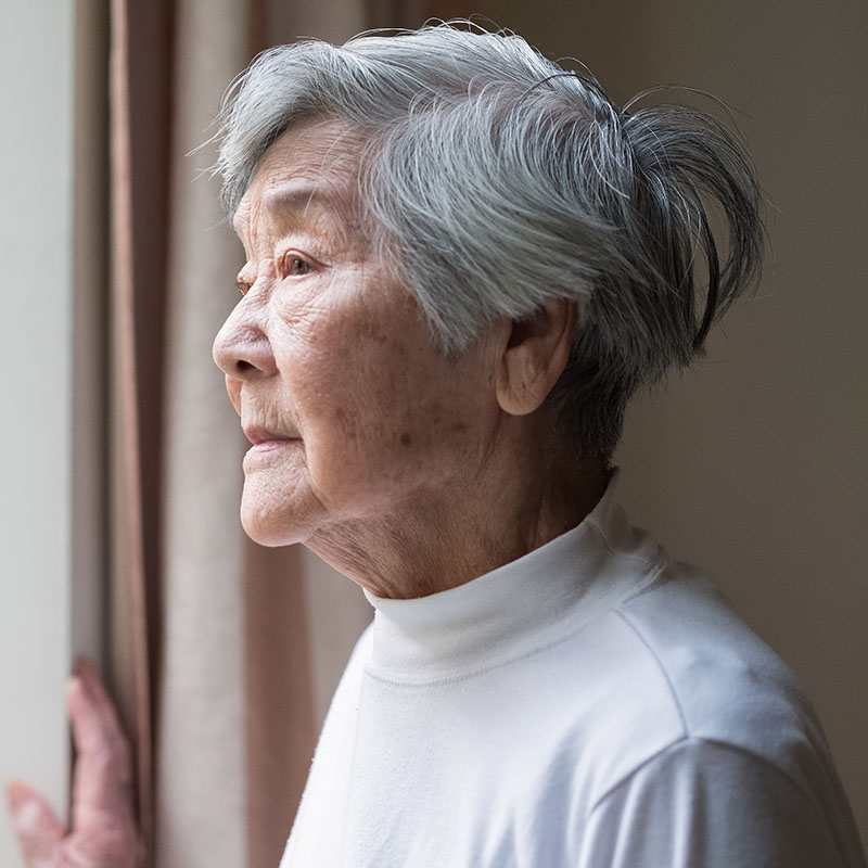 Chinese senior woman looking outside