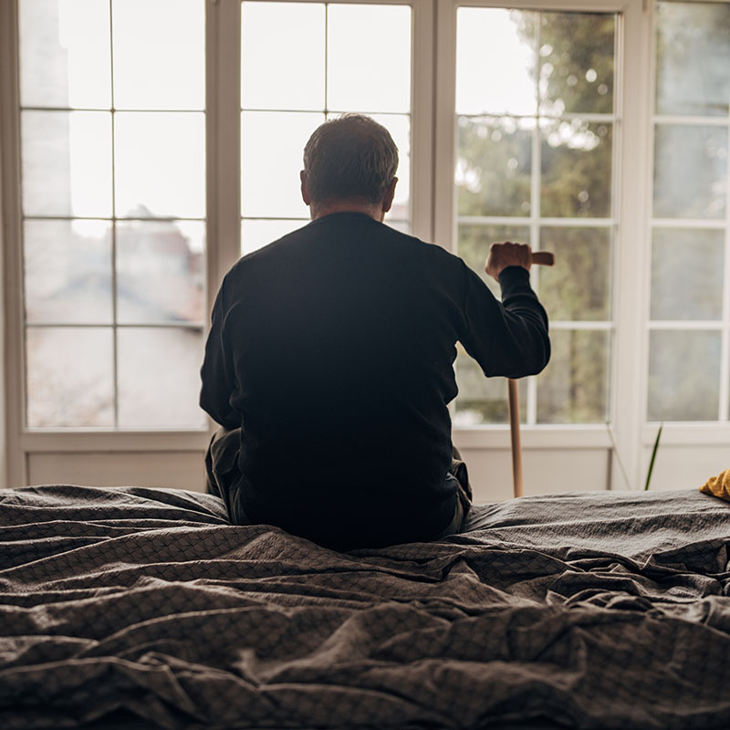 A lonely man is sitting on the bed
