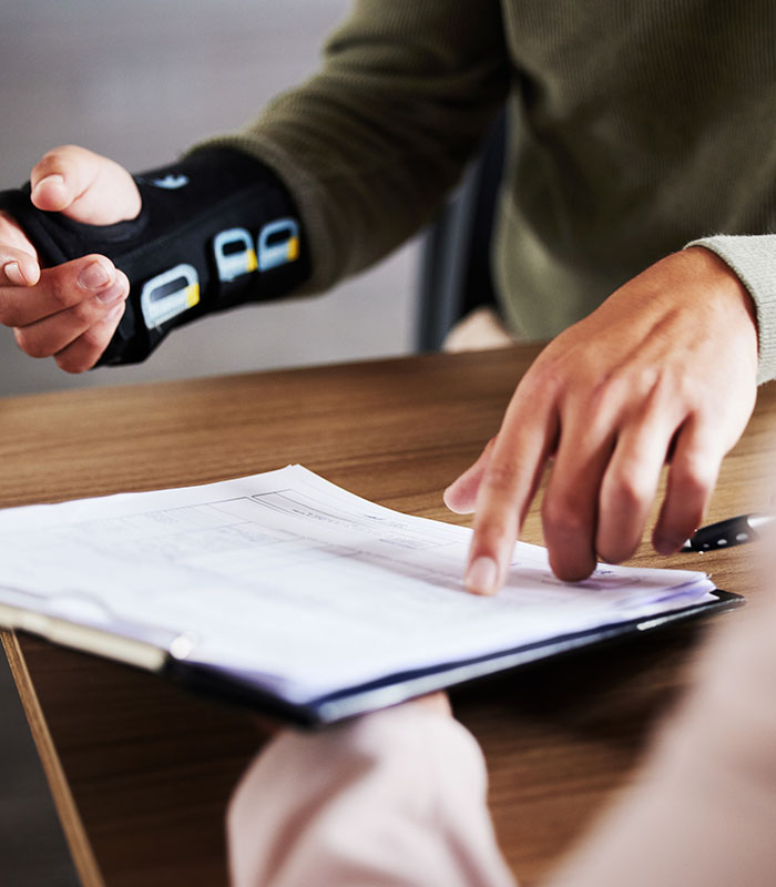 compensation and man hands with insurance documents, legal contract and paperwork